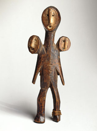 Unidentified Lega artist, “Three-Headed Figure (Sakimatwemtwe),” South Kivu or Maniema province, Democratic Republic of the Congo, wood, fiber, kaolin, nineteenth century (Brooklyn Museum, Museum Expedition 1922, Robert B. Woodward Memorial Fund)