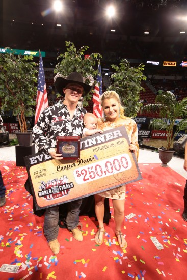 Cooper Davis poses with his wife, Kaitlyn, their son, Mackston, and a big check at the PBR World Finals in Las Vegas (photo by Andy Watson)