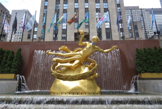 A masked Prometheus rules over flags at Rockefeller Center celebrating the resiliency of New York City (photo by twi-ny/mdr)